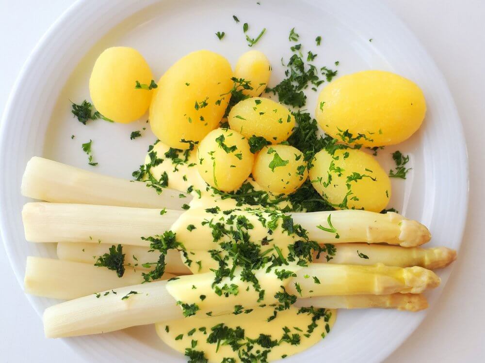 Blick auf einen Teller mit Spargel, Kartoffeln und Soße