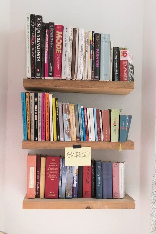 Blick auf ein Bücherregal, daran klebt ein Zettel mit der Aufschrift "Bafög"