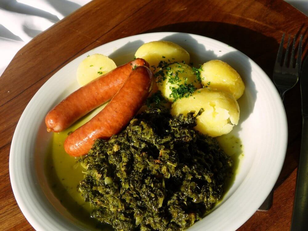 Ein Teller mit Grünkohl, Kartoffeln und Mettwurst